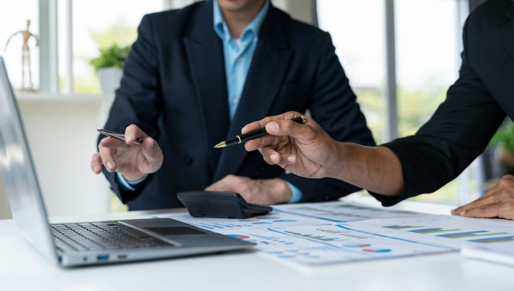 Group of young businessmen analyzing investment, income, tax, accounting data from data graphs. Fina